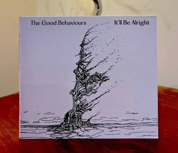 The It'll Be Alright CD gatefold wallet standing on a wooden table