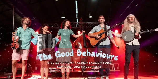The band on stage under red light, titled It'll Be Alright album launch tour, September and October 2024